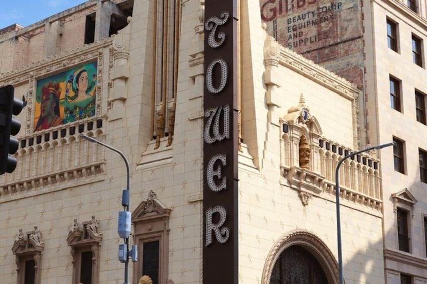 A building with a large sign that reads 'Tower' and a mural on the side. 4