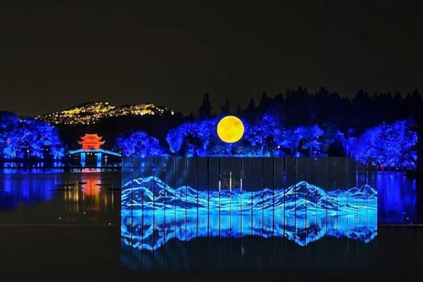 A night scene with illuminated trees, a reflection of a traditional building, and a full moon. 1