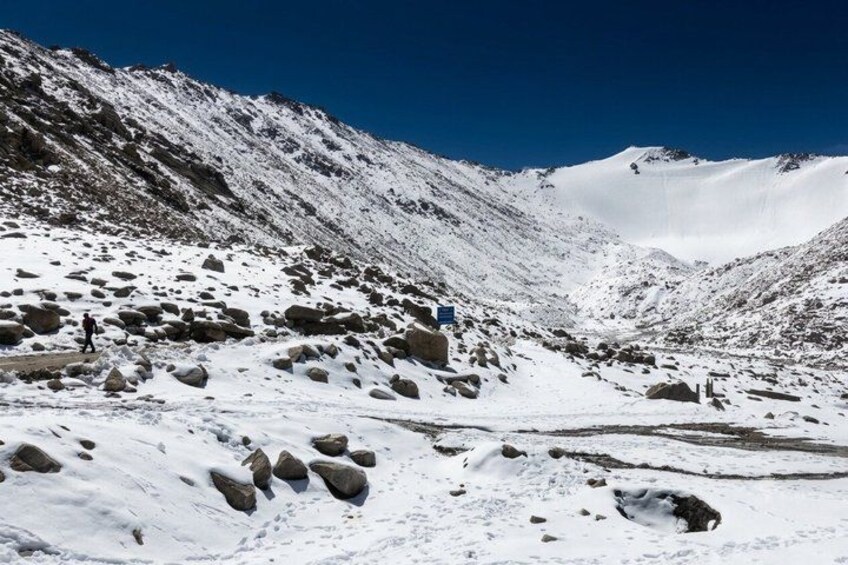 Paisaje montañoso nevado con terreno rocoso y cielo azul despejado. 5