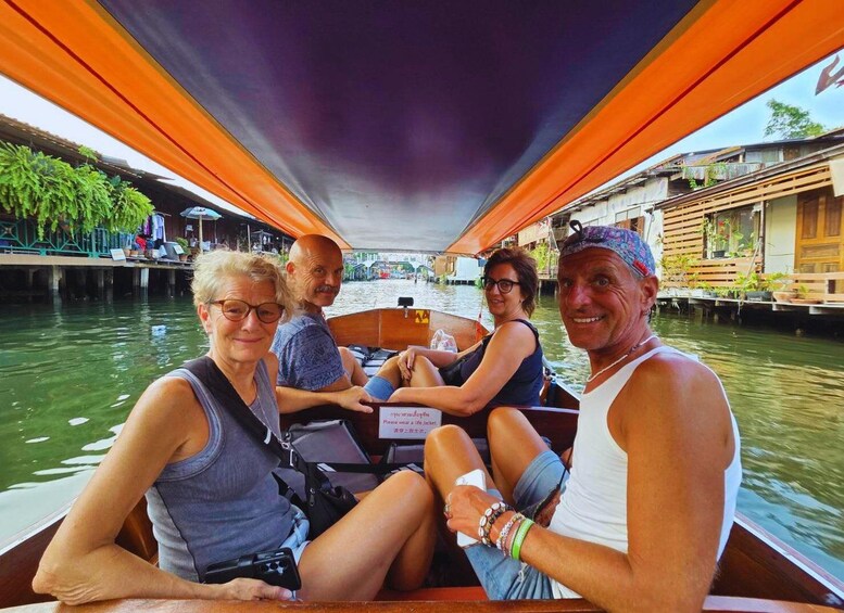 A narrow boat with four passengers, surrounded by water and traditional buildings. 3