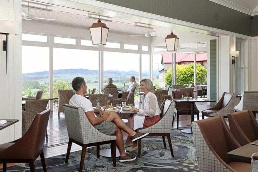 A restaurant with outdoor seating, large windows, and a view of the landscape. 4