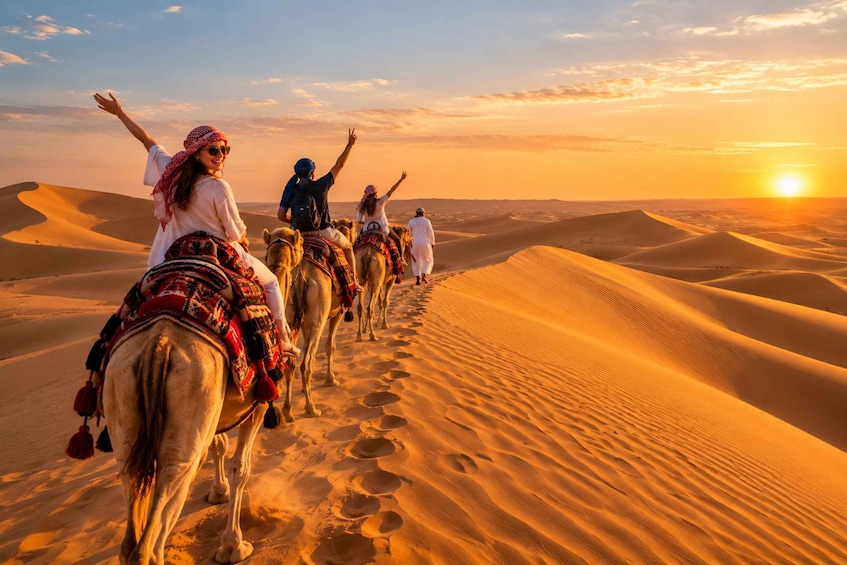 A group of people riding camels across a desert landscape with sand dunes and a sunset in the background. 2