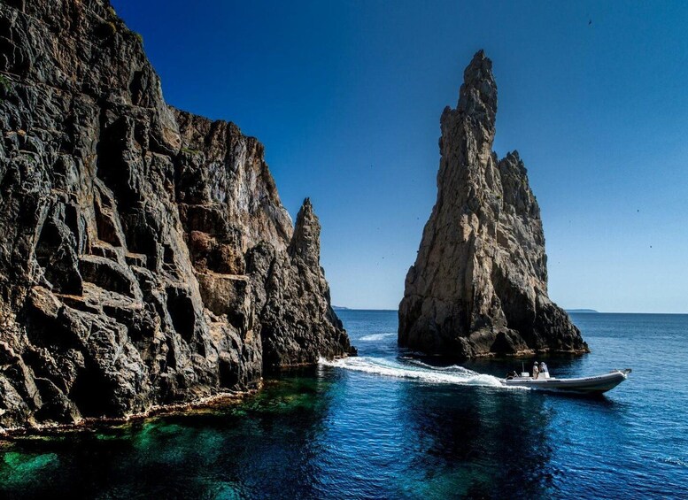 A rocky coastline with a boat navigating between two prominent rock formations. 4