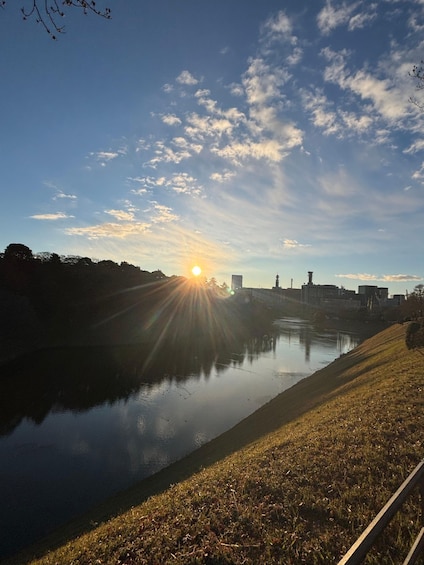 A river reflecting the sun with a city skyline in the background. 1