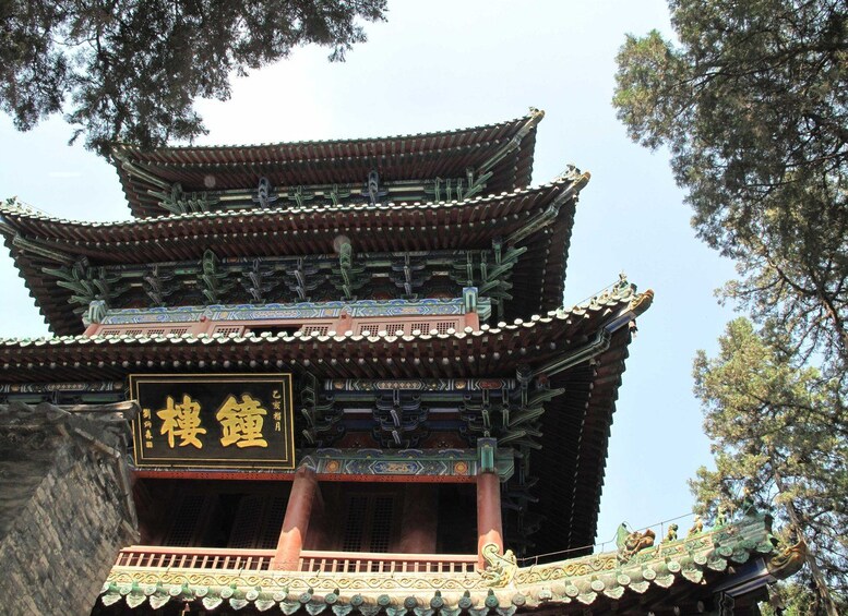 A traditional multi-tiered pagoda with ornate decorations and a sign with Chinese characters. 2