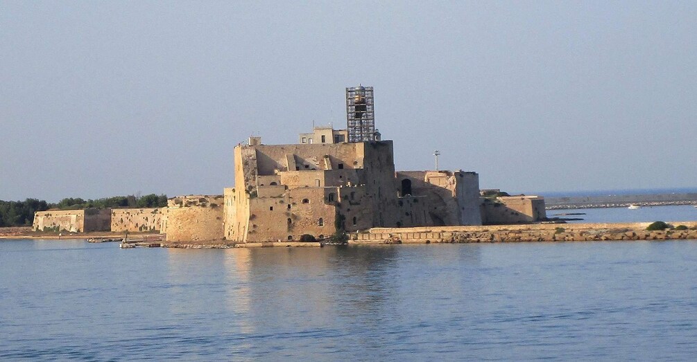 A fortified structure with a central tower, surrounded by water. 1