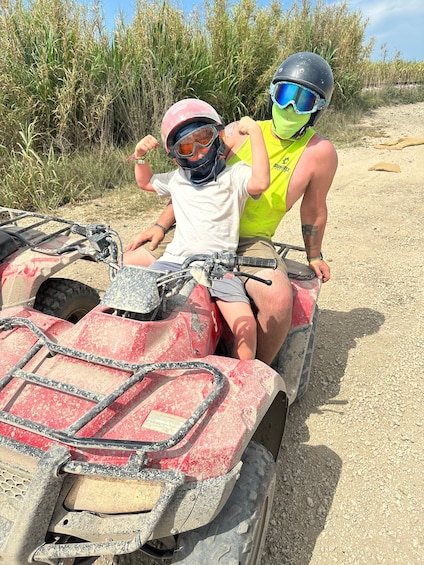 Two people on an ATV in a dry, grassy area. 5
