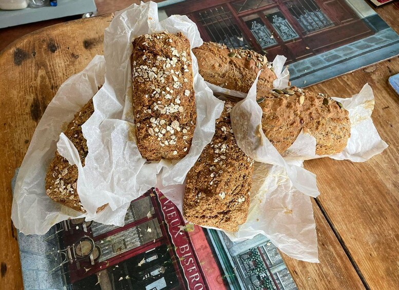 Several loaves of bread on parchment paper on a wooden table. 5