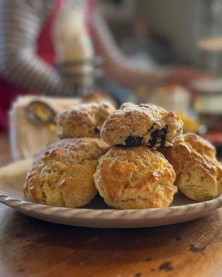 A plate of scones with a dusting of powdered sugar. 2
