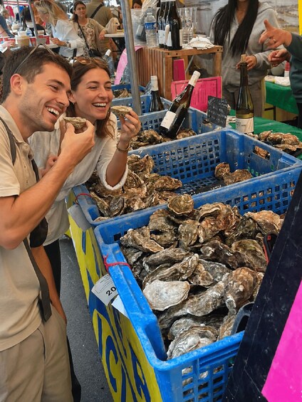 A market stall with oysters and a bottle of wine. 1