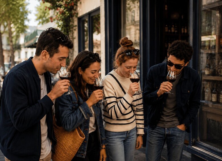 Four people tasting wine outdoors. 2