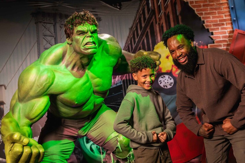 Una persona disfrazada de Hulk, un niño y un adulto en un ambiente relajado. 5