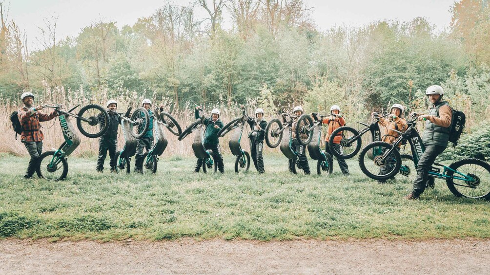 Eine Gruppe von Mountainbikern in einer Wiese, im Hintergrund Bäume. 4
