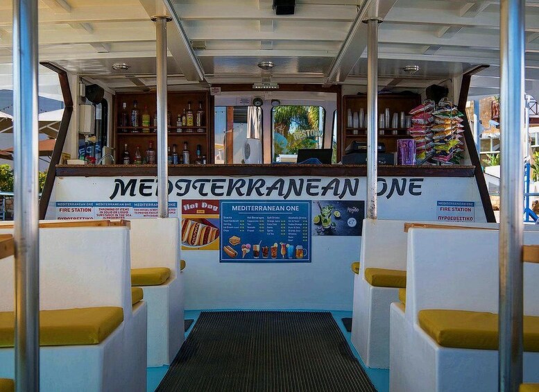 A ferry with a bar area, seating, and a menu board. 2