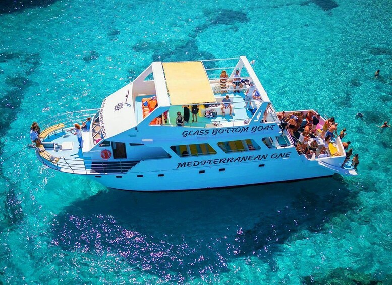 A large boat named 'Glasses Bottom Boat' with people on board and in the water. 1