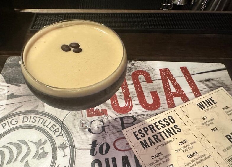 Un cóctel con una espuma en la parte superior, un menú con la palabra 'ESPRESSO' visible y el logotipo de 'PIG DISTILLERY'. 2