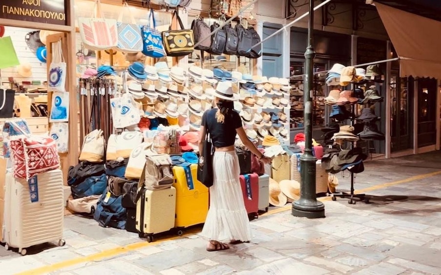 A street market with various bags and hats on display. 4