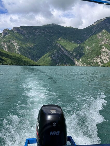 En båd sejler på en sø med bjerge i baggrunden. 2