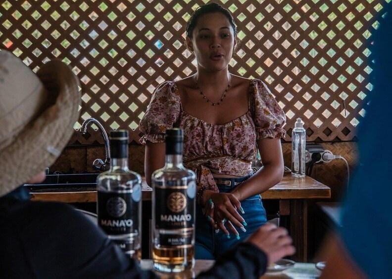 Una persona sentada en una mesa con una botella de ManO. 5