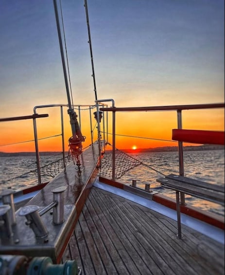 A wooden deck on a boat with a sunset in the background. 1