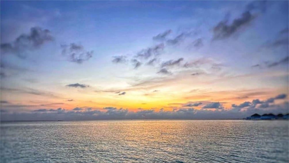 A sunset over a calm sea with scattered clouds. 2