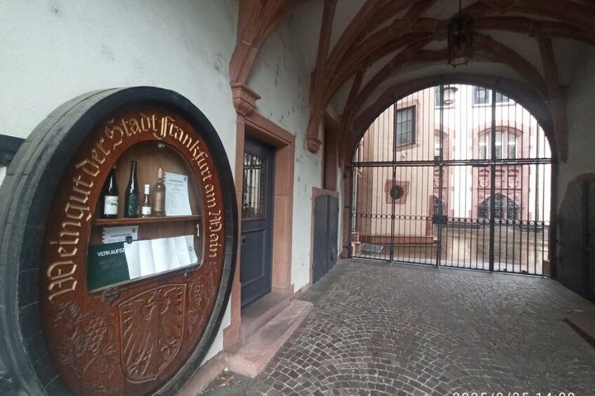 A cobblestone street with a wooden barrel window and a wrought iron gate. 2
