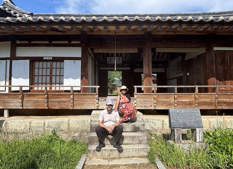 A traditional wooden building with a tiled roof and a stone staircase leading up to it. 5