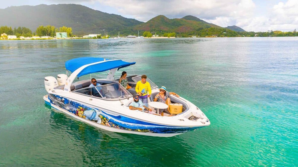 A motorboat with a blue canopy on a clear turquoise lake surrounded by mountains. 4