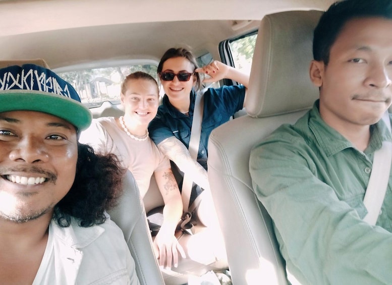 Cuatro personas sentadas en un coche con asientos de cuero color beige. 2