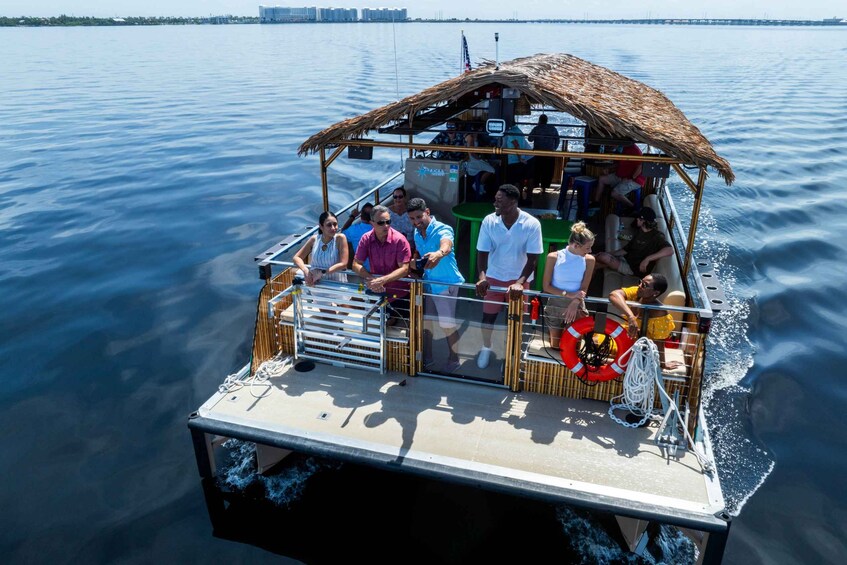 A boat with a thatched roof and passengers enjoying the water. 2