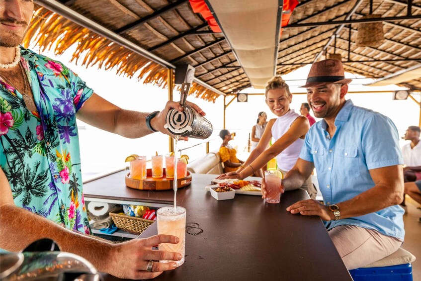 A tropical outdoor setting with people enjoying drinks and food. 3