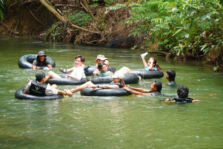 People floating on tubes in a river surrounded by greenery. 3