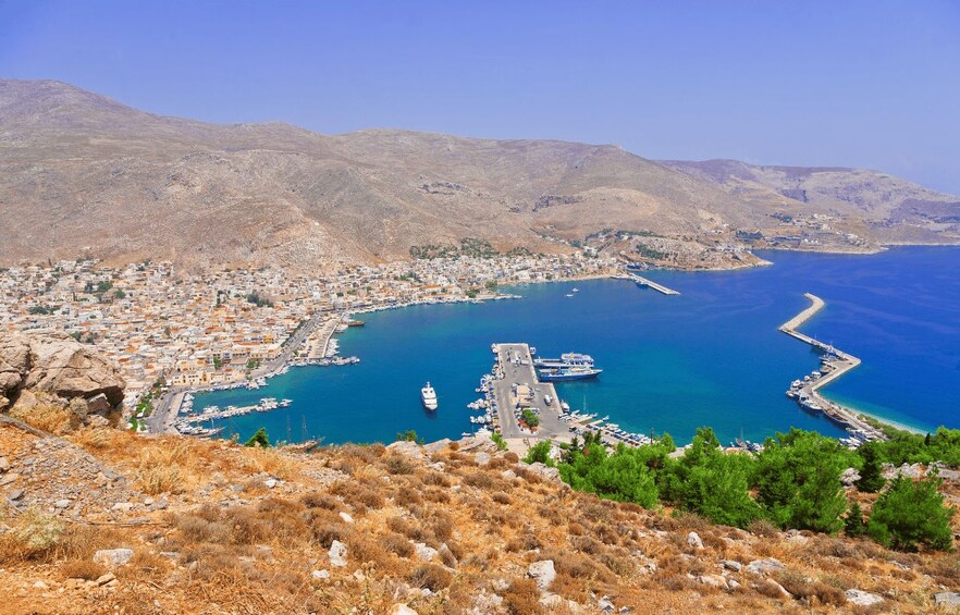 A coastal town with a harbor, boats, and a mountainous backdrop. 4