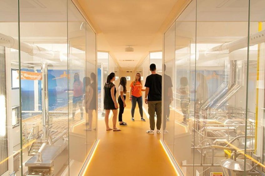 A modern interior with glass walls, a yellow floor, and people walking. 5