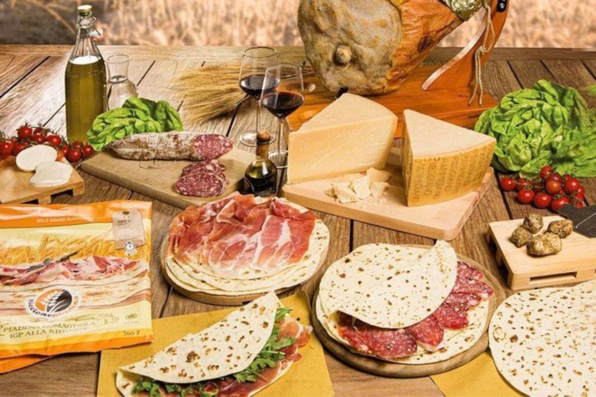 A variety of cheeses, cured meats, and fresh vegetables on a wooden table. 1