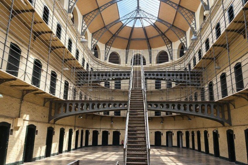 A multi-level atrium with a central staircase, arched windows, and a dome ceiling. 3