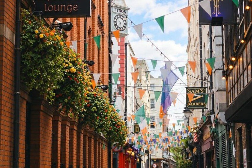 A street with buildings, a clock, and hanging flags. 4