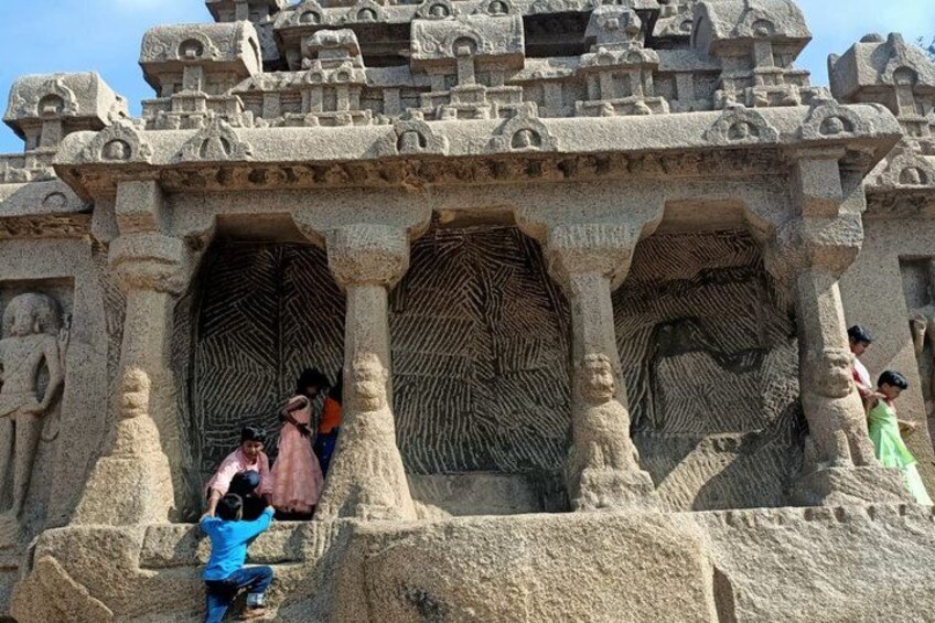 A stone temple with intricate carvings and three large doorways. 5
