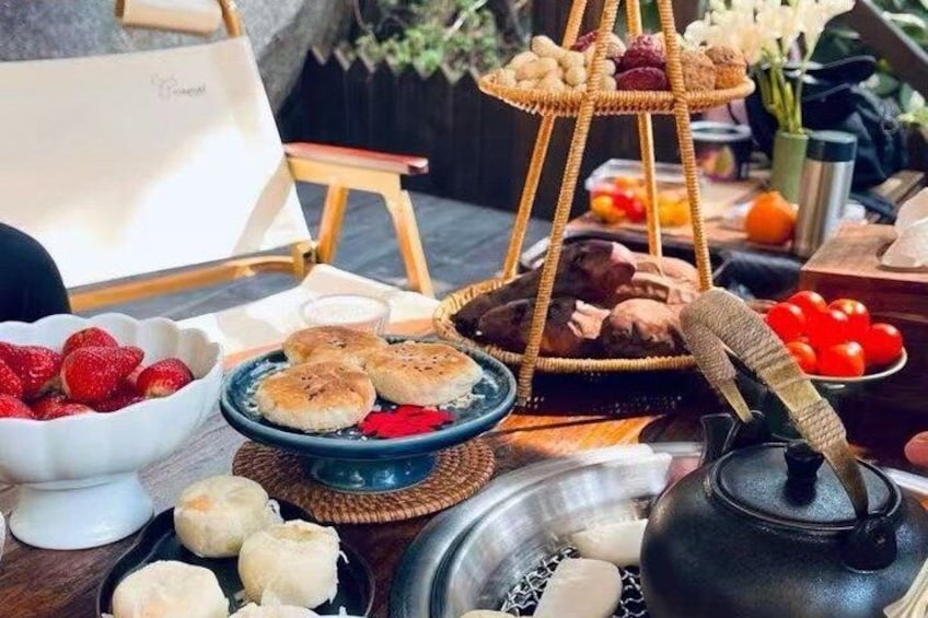 A table with various food items, including strawberries, pastries, and a teapot. 3