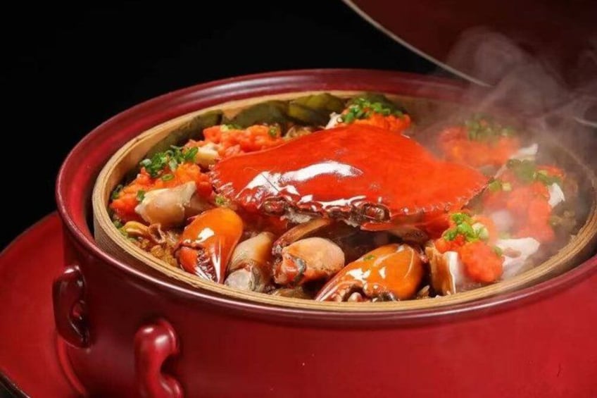A red pot with a crab and vegetables. 5