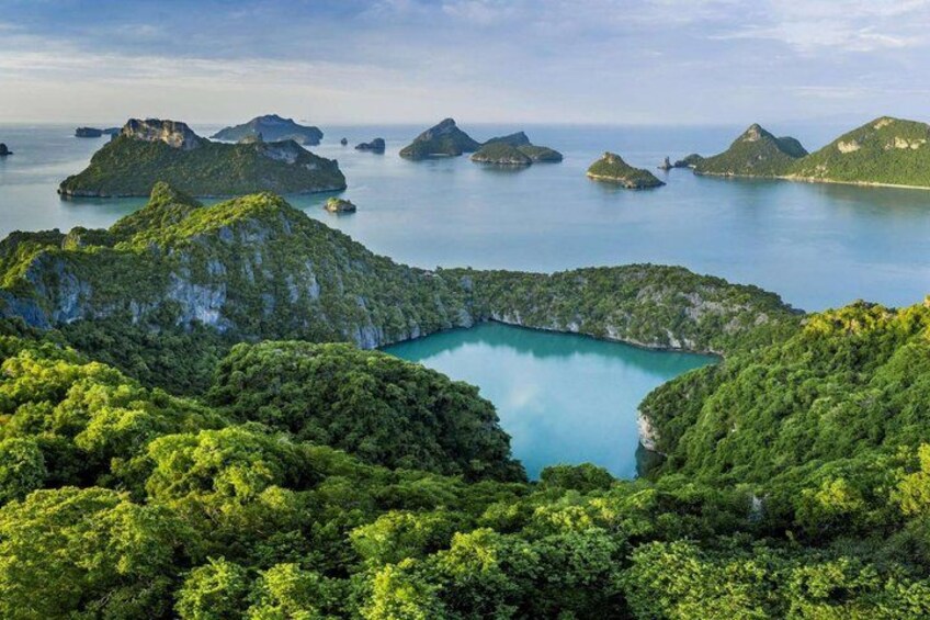 A coastal landscape with lush green hills and a turquoise bay surrounded by small islands. 5