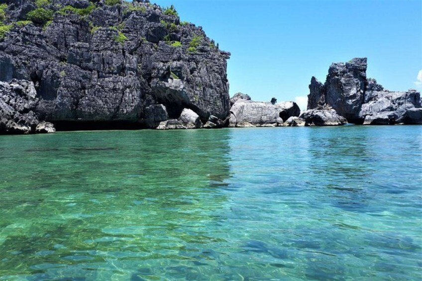 Clear turquoise water, rocky cliffs, and lush greenery. 3