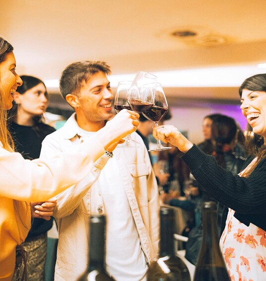 A group of people toasting with wine glasses in a social setting. 1