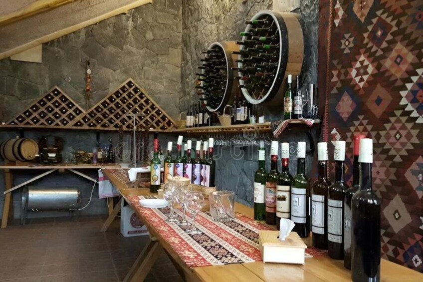 A wine cellar with wooden racks, wine bottles, and a wooden table. 2