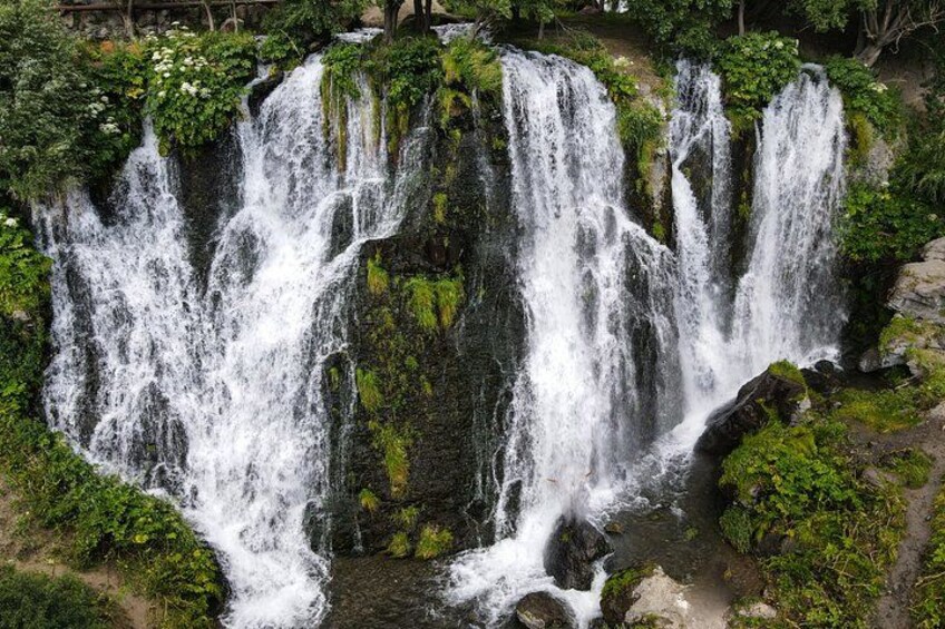 A multi-tiered waterfall surrounded by lush greenery. 5
