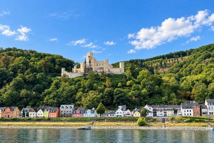 A castle on a hill, a river, and colorful houses along the riverbank. 5