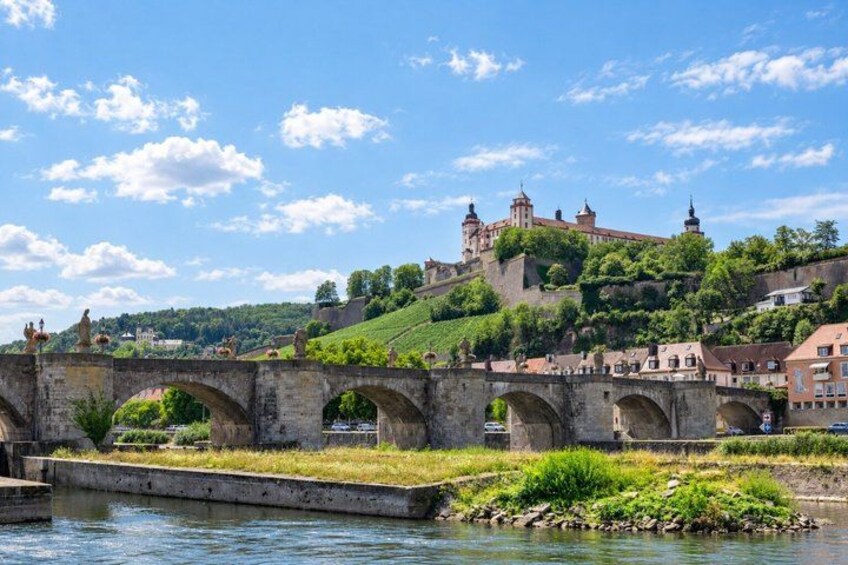A stone bridge over a river, a castle on a hill, and lush greenery. 5