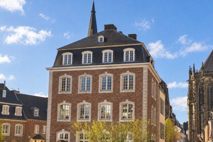 Un bâtiment en briques rouges, doté de nombreuses fenêtres et surmonté d’une flèche. 5