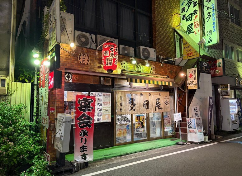 A Japanese restaurant with neon signs and a green awning. 5