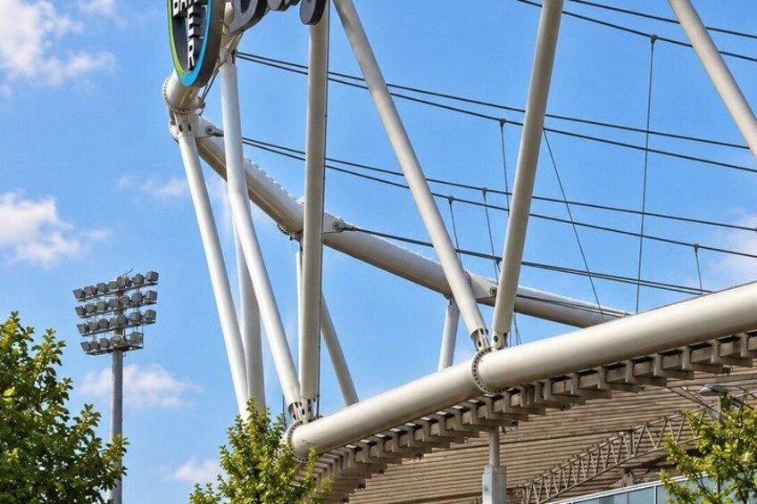 A stadium structure with a prominent roof and lighting system. 3